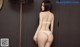 A woman in a white lingerie standing in front of a mirror.