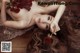 A woman laying on the floor holding a bunch of red roses.