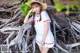 A woman in a white dress and a straw hat posing for a picture.