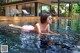 A woman in a pink bikini laying in a pool.