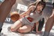 A woman sitting on the ground holding a basketball.