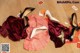 A pile of shoes and a dress on a wooden floor.