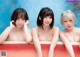 A group of three naked women sitting in a bathtub.