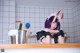 A woman with purple hair and horns sitting at a counter.