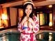 A woman in a red and white kimono standing next to a pool.