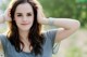 A beautiful young woman posing for a picture in a field.